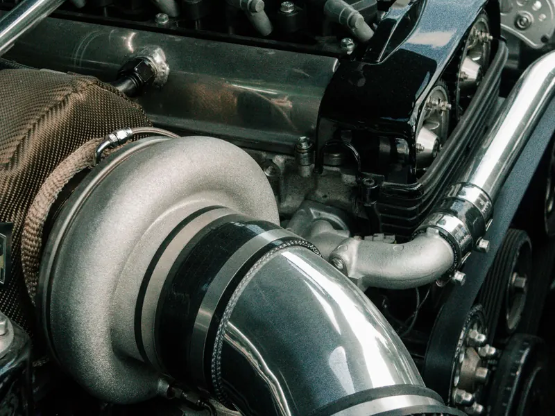 Close-up of a turbocharged engine bay with an air intake and pipework